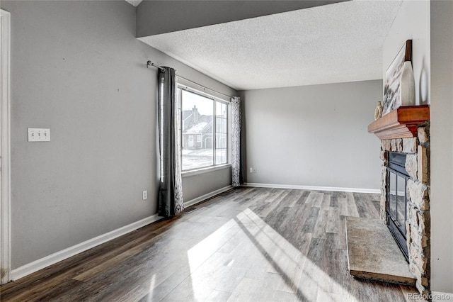 living room featuring wood-type flooring, a fireplace, and a textured ceiling