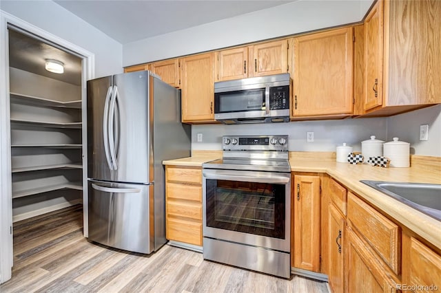 kitchen featuring sink, appliances with stainless steel finishes, and light wood-type flooring