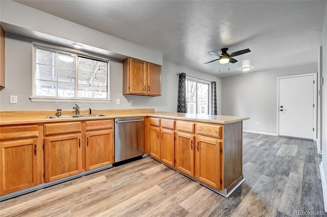 kitchen featuring kitchen peninsula, ceiling fan, light wood-type flooring, stainless steel dishwasher, and sink