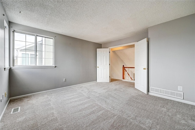 unfurnished bedroom featuring carpet floors and a textured ceiling