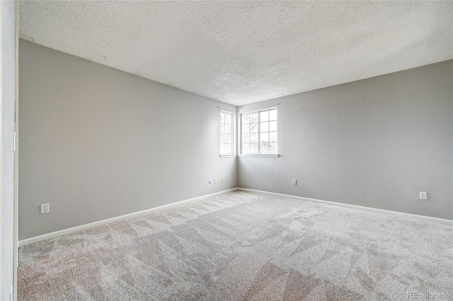 carpeted spare room featuring a textured ceiling