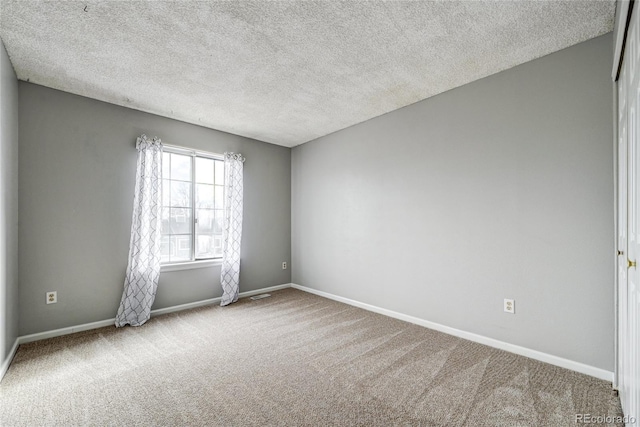 carpeted spare room with a textured ceiling