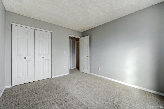 unfurnished bedroom with a textured ceiling, a closet, and light carpet