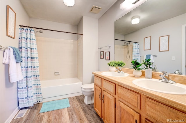 full bathroom featuring toilet, shower / bathtub combination with curtain, hardwood / wood-style floors, and vanity