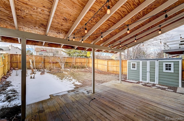 snow covered deck featuring a storage unit