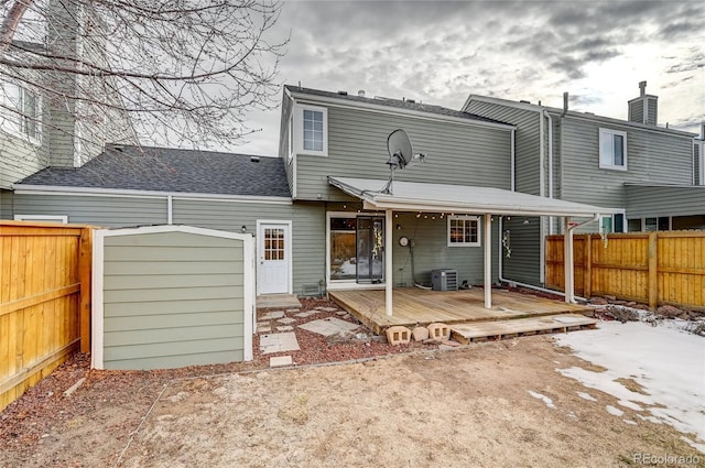 back of property with central AC and a wooden deck