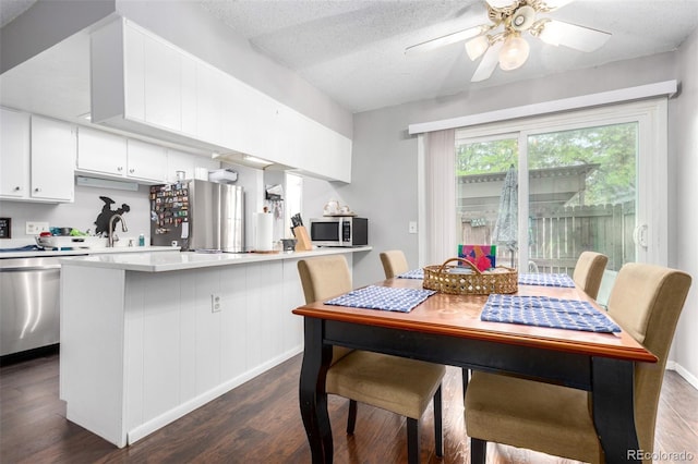 1977 S Oakland Way, Aurora, CO 80014 - kitchen with stainless steel appliances, dark wood finished floors, white cabinets, a peninsula, and a textured ceiling