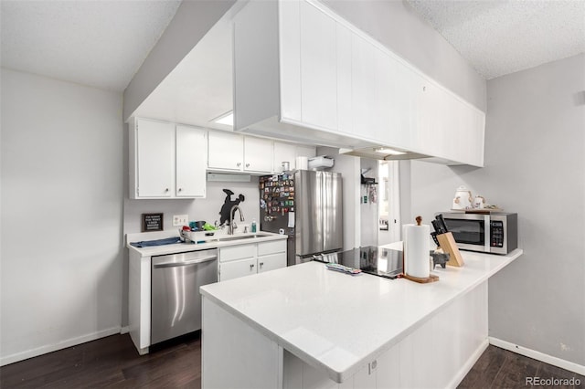 1977 S Oakland Way, Aurora, CO 80014 - kitchen with stainless steel appliances, dark wood-style floors, light countertops, a peninsula, and a textured ceiling