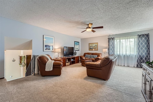 living area featuring a textured ceiling, ceiling fan, and light carpet