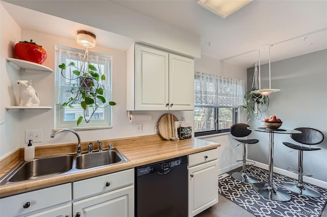 kitchen featuring a sink, light countertops, black dishwasher, white cabinetry, and dark wood-type flooring