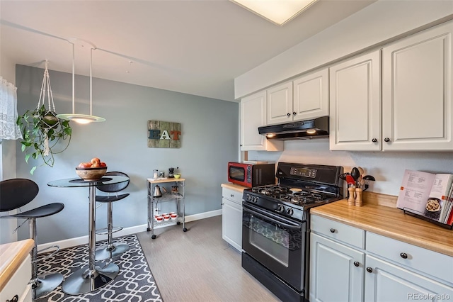 kitchen featuring under cabinet range hood, white cabinetry, light wood-style floors, and black gas stove