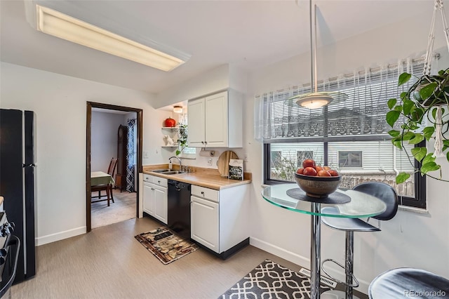 kitchen featuring white cabinets, a sink, light countertops, dark wood-type flooring, and black appliances