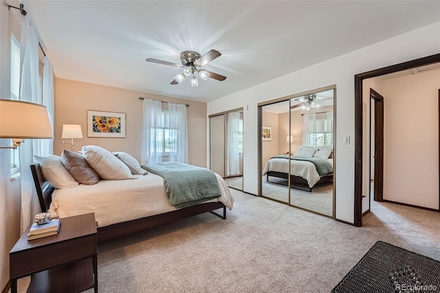 bedroom featuring a ceiling fan, multiple closets, and carpet