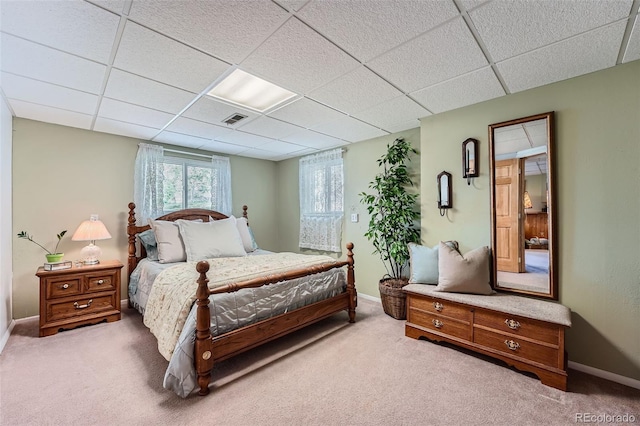bedroom with carpet floors, a paneled ceiling, and baseboards