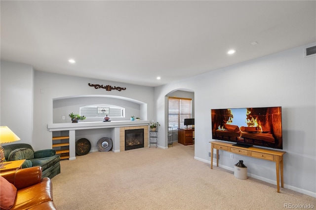 carpeted living room with a tiled fireplace