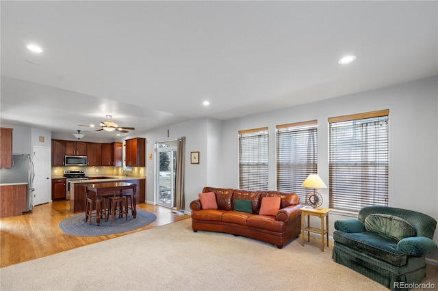 living room with ceiling fan and light carpet