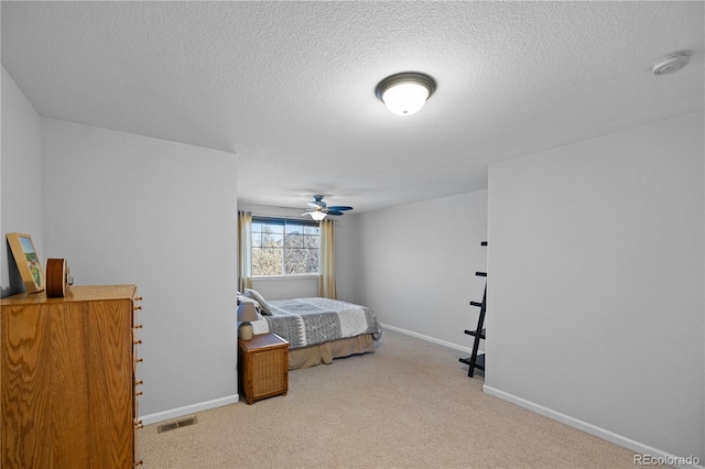 bedroom with a textured ceiling and light colored carpet