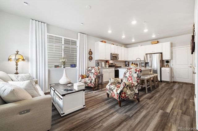 living area featuring dark wood-type flooring and recessed lighting