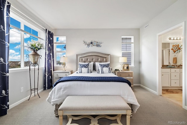 carpeted bedroom featuring baseboards, ensuite bath, and visible vents