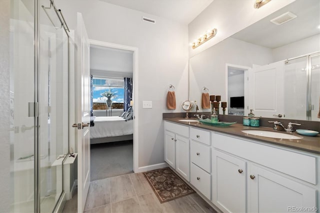 full bathroom featuring visible vents, double vanity, ensuite bathroom, a shower stall, and a sink