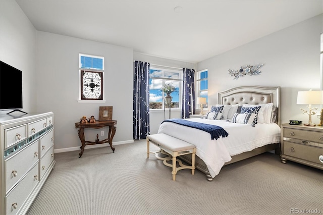 bedroom with baseboards and light carpet