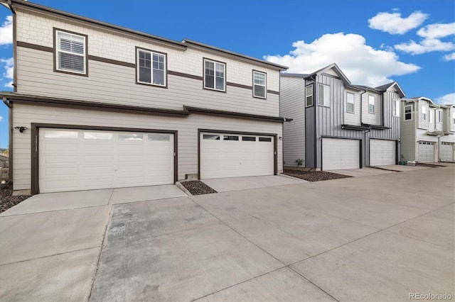 multi unit property featuring an attached garage and concrete driveway