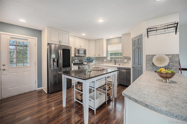 9075 Jill Dr, Conifer, CO 80433 - kitchen featuring appliances with stainless steel finishes, plenty of natural light, decorative backsplash, dark wood-style floors, and recessed lighting