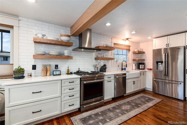 kitchen featuring wall chimney range hood, decorative backsplash, open shelves, a sink, and stainless steel appliances