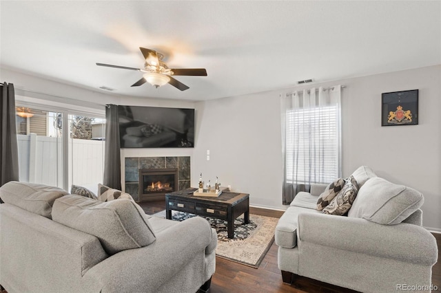living room with ceiling fan, a fireplace, dark hardwood / wood-style flooring, and a wealth of natural light