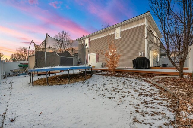 snow covered property with a trampoline