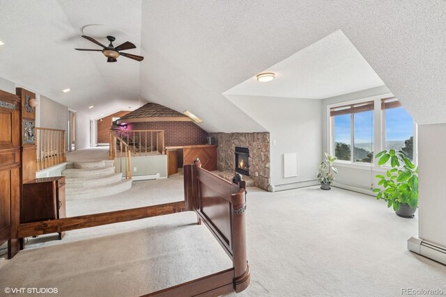22081 Paradise Cir, Golden, CO 80401 - interior space featuring carpet floors, vaulted ceiling, a baseboard radiator, a stone fireplace, and a textured ceiling