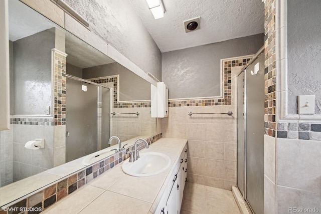 22081 Paradise Cir, Golden, CO 80401 - bathroom with tile walls, a shower stall, vanity, tile patterned floors, and a textured ceiling
