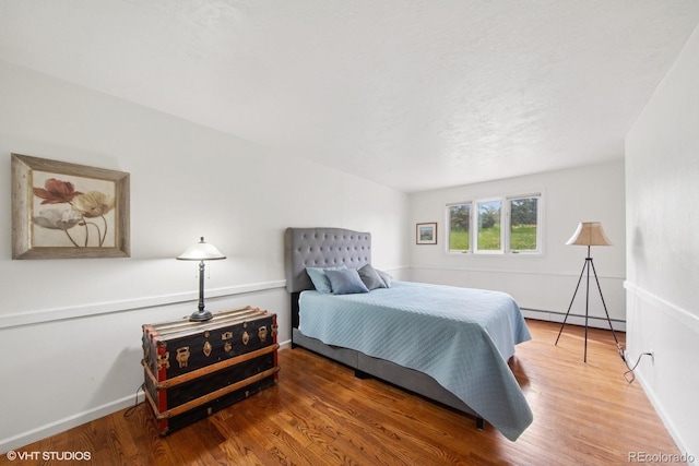 22081 Paradise Cir, Golden, CO 80401 - bedroom featuring baseboard heating, wood finished floors, and baseboards