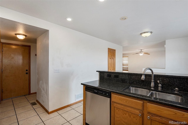 kitchen with ceiling fan, sink, stainless steel dishwasher, dark stone countertops, and light tile patterned flooring