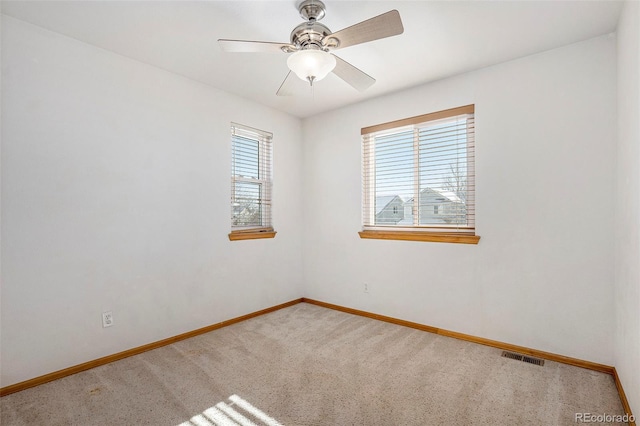 carpeted spare room with ceiling fan