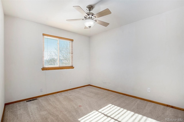 carpeted spare room featuring ceiling fan