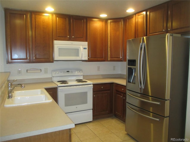 kitchen with white appliances, sink, and light tile patterned floors