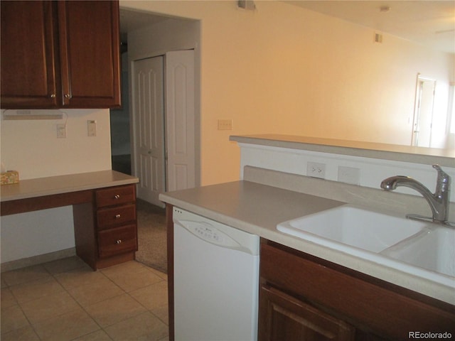 kitchen with white dishwasher, built in desk, sink, and light tile patterned floors