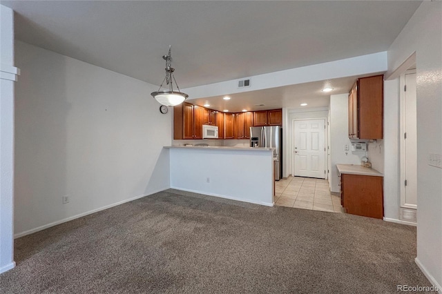 kitchen with pendant lighting, light colored carpet, kitchen peninsula, and stainless steel refrigerator with ice dispenser