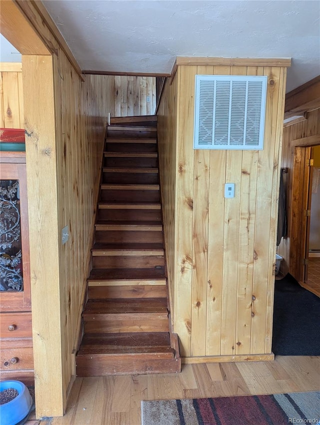 stairway with wood-type flooring and wood walls