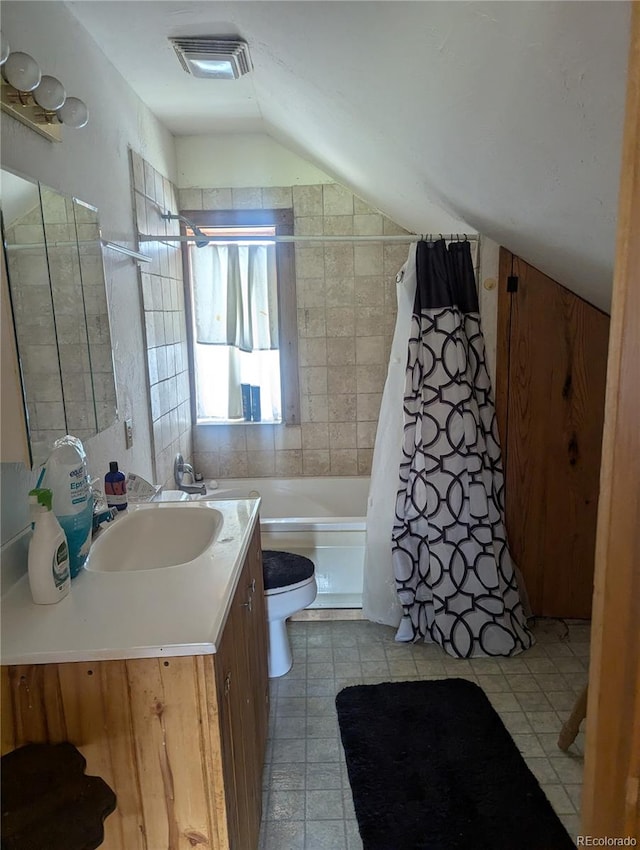 full bathroom featuring vanity, vaulted ceiling, toilet, tile walls, and shower / tub combo