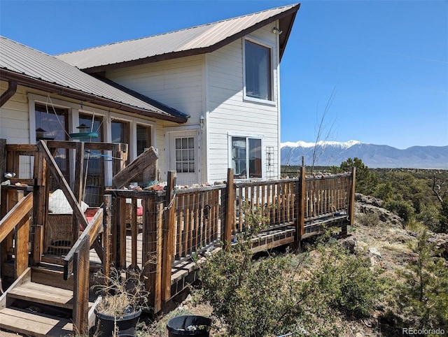 rear view of house with a deck with mountain view