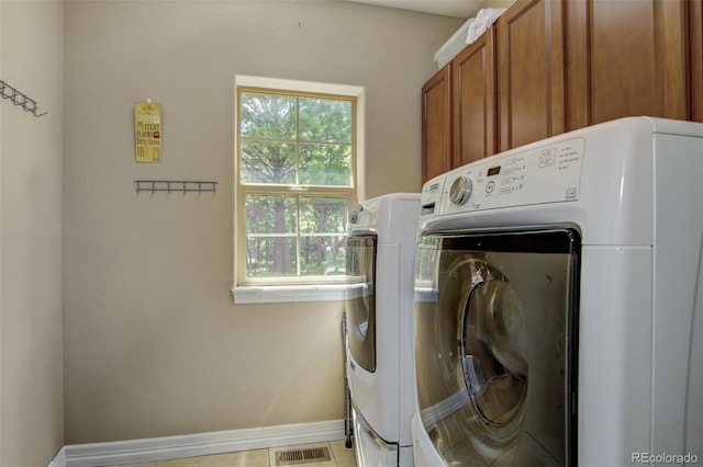 laundry area with cabinets and washing machine and clothes dryer