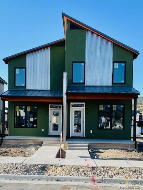 modern home featuring a porch, a standing seam roof, and metal roof