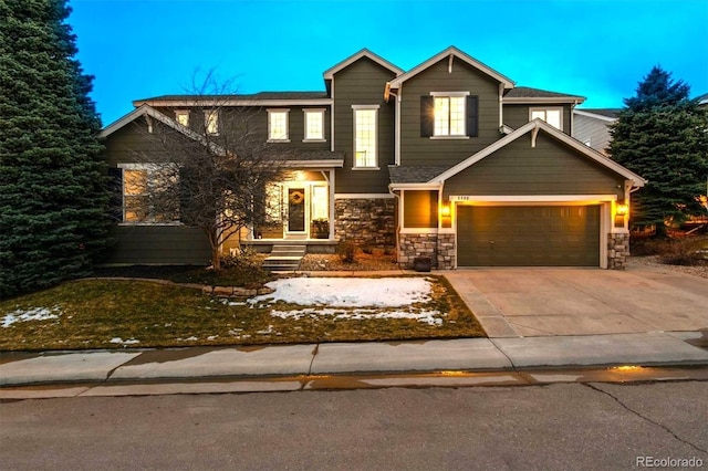 view of front of property featuring a garage, stone siding, and driveway