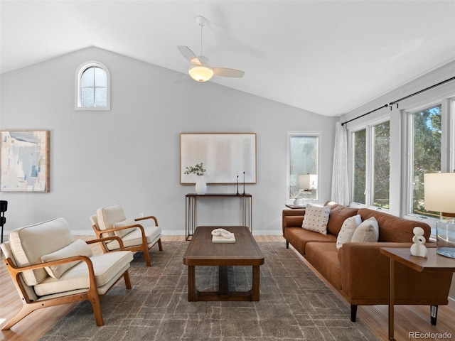 living area with vaulted ceiling, dark wood-type flooring, a ceiling fan, and baseboards