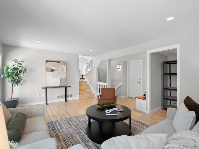 living area with stairway, light wood-style flooring, visible vents, and recessed lighting