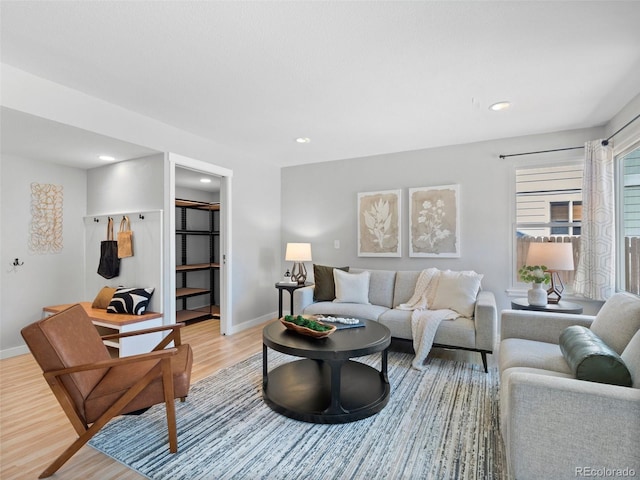 living room with light wood finished floors, baseboards, and recessed lighting