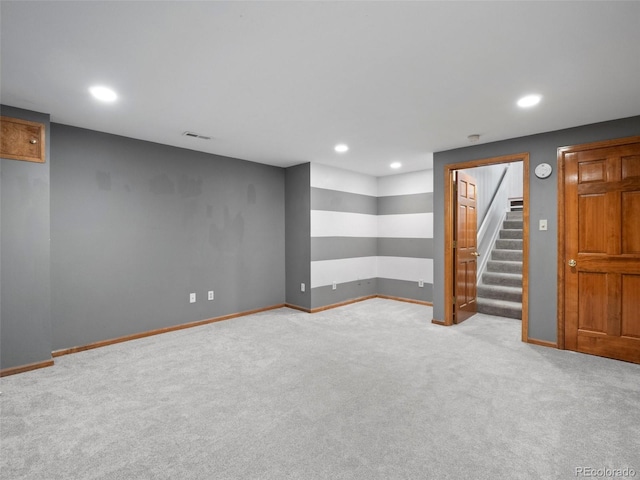 finished basement featuring recessed lighting, visible vents, baseboards, stairs, and carpet