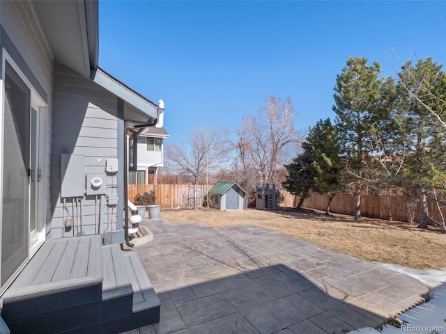 view of patio / terrace featuring a fenced backyard, an outdoor structure, and a storage unit